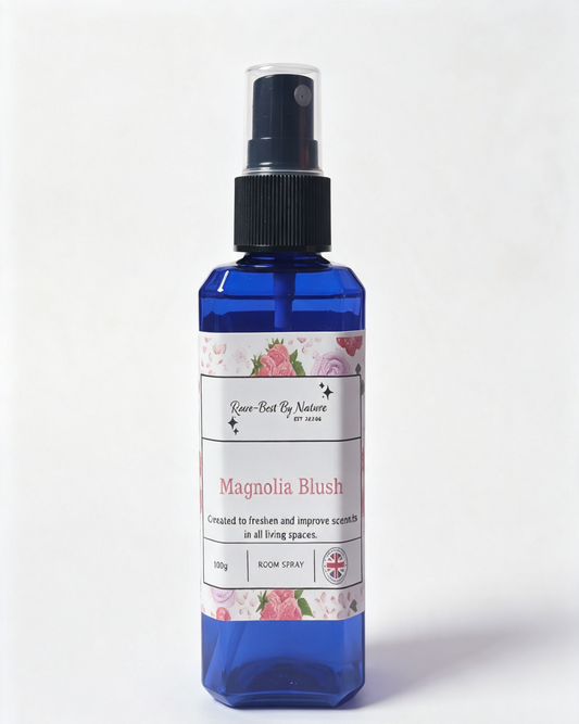 A blue room spray bottle with a black spray nozzle and a white label featuring pink floral illustrations. The label reads 'Rowe-Rest By Nature' and 'Magnolia Blush'.