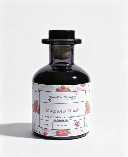 A 150ml diffuser bottle by Row-Best By Nature, featuring a black glass body, black screw cap, and a white label decorated with pink rose illustrations and the scent name 'Magnolia Blush'.